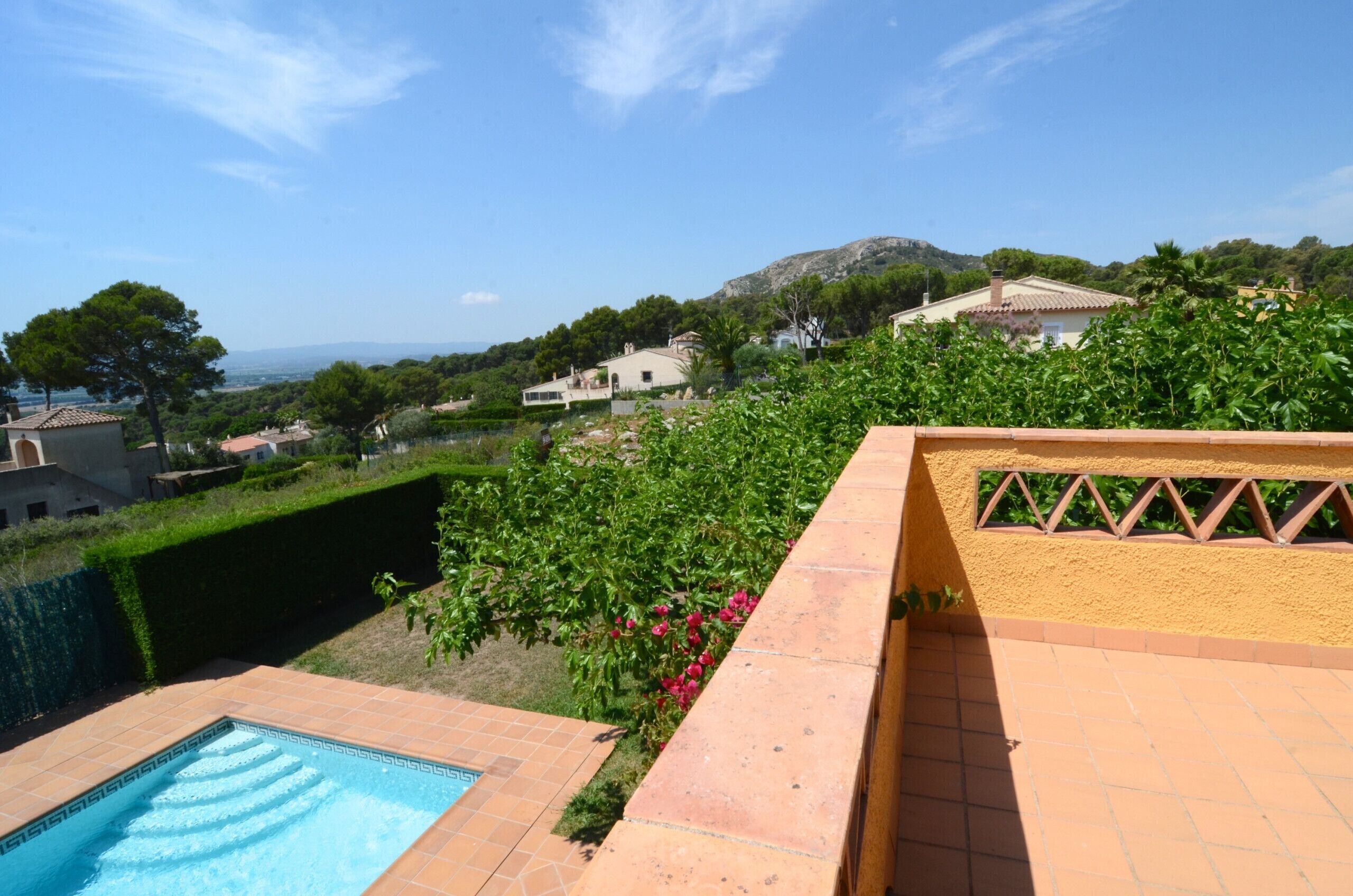 Un espace piscine offrant une vue sur une colline et des maisons.