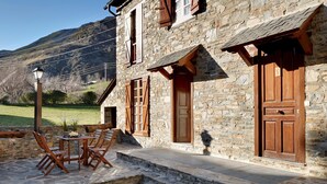 A stone building with wooden shutters and a stone staircase leading to a door. - Besiberri by FeelFree Rentals (Garós)