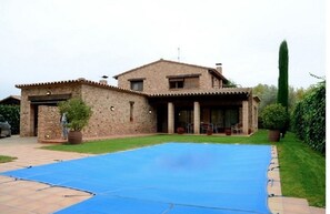Una casa con una amplia piscina azul en el patio trasero.
