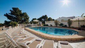 A poolside area with lounge chairs and a swimming pool. - Villa Benicuco 24 - PlusHolidays (Calpe)