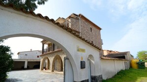 Un bâtiment en pierre avec une façade blanche, une entrée en arc de cercle et une enseigne indiquant « EMPORIUM ».