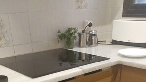 Une cuisine avec des meubles de rangement en bois, un four noir et un plan de travail blanc.