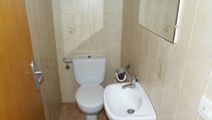 Une petite salle de bain avec des toilettes et un lavabo.