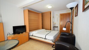 A compact hotel room with a bed, a television, a desk, and a chair. - MIRAMAR PLAYA (STUDIO) (Benidorm)