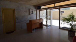 A reception area with a wooden bench, a potted plant, and a door. - MIRAMAR PLAYA (STUDIO) (Benidorm)