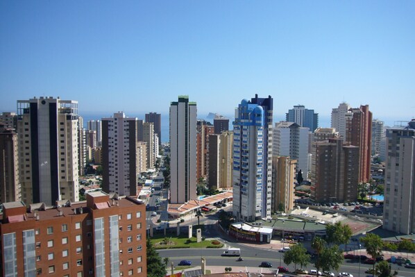 A high-rise urban area with modern buildings, a clear sky, and a road with vehicles. - GEMELOS 12 (1 BEDROOM) (Benidorm)