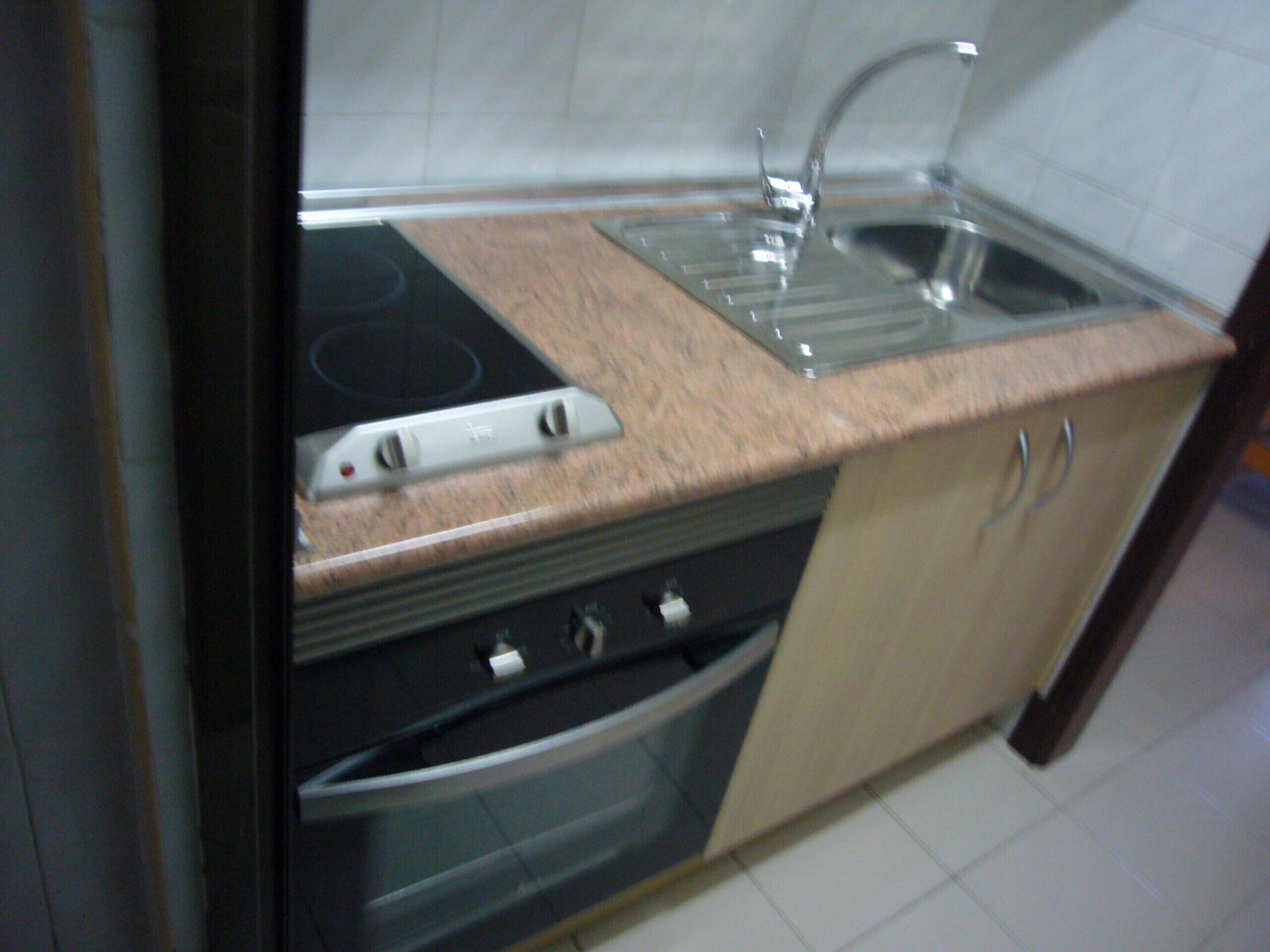 A kitchen with a stove, oven, and sink.