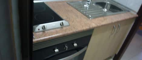 Una cocina con estufa, horno y lavaplatos.