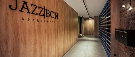 A hallway with a wooden wall displaying the text "JAZZBCN APARTMENTS".