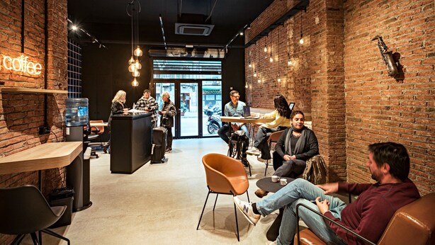 A modern coffee shop with brick walls, hanging lights, and a bar area.