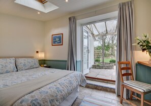 Relax in a serene bedroom with a large bed, a comfortable chair, and a beautiful view of the outdoors.