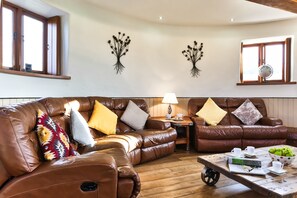A living room with leather sofas, a coffee table, and decorative wall art.