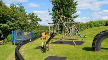 Children can play safely on the playground equipment, including a swing set, seesaw, and climbing structure.