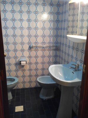A bathroom with a patterned tile wall, a sink, a toilet, and a bidet. - ALHAMBRA (1Bedroom) (Benidorm)