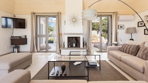 Una sala moderna con chimenea, un televisor de pantalla plana y un sofá.