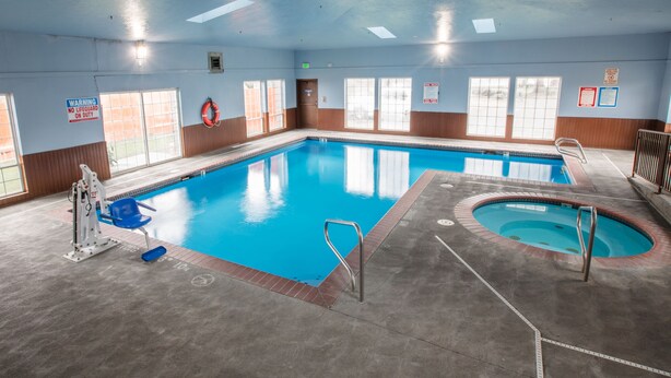 Une piscine intérieure équipée d’un poste de surveillance pour le sauveteur, d’un jacuzzi et d’un escalier d’accès à la piscine.