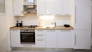 Eine moderne Küche mit weißen Schränken, Edelstahlgeräten und einer Holz Arbeitsplatte.