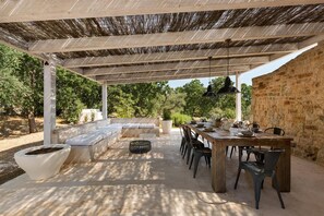 En uteplats med ett matbord, stolar, en soffa och en pergola.