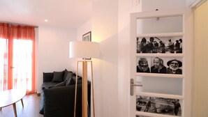 Una habitación moderna con una cama, una lámpara de pie y una pared decorada con fotografías en blanco y negro.