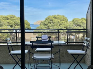 A balcony with a view of the sea, equipped with folding chairs and a table. - Beautiful apartment in front of the sea (Estartit)