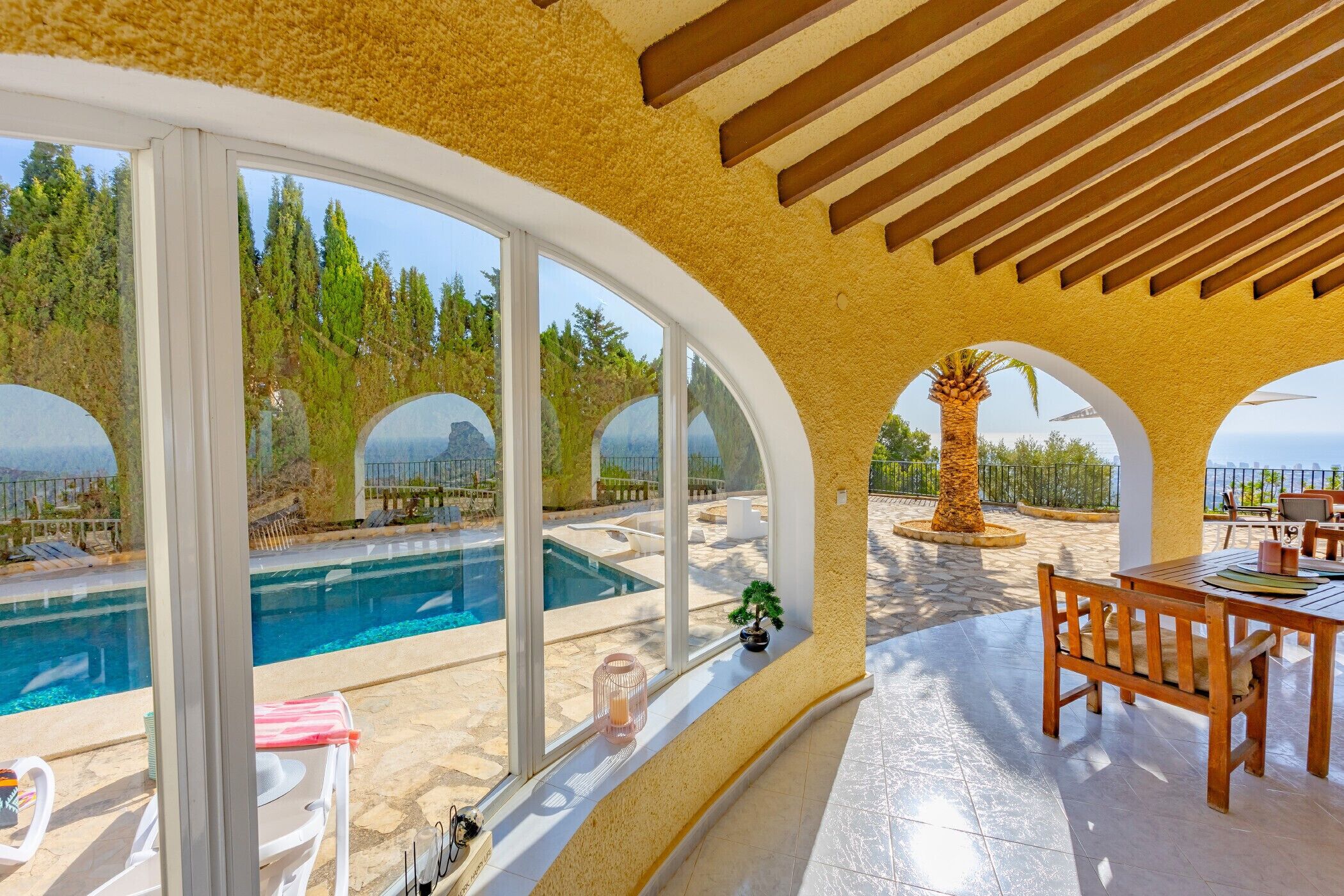 Ein Poolbereich mit Blick auf den Pool, einem Holztisch und Stühlen.