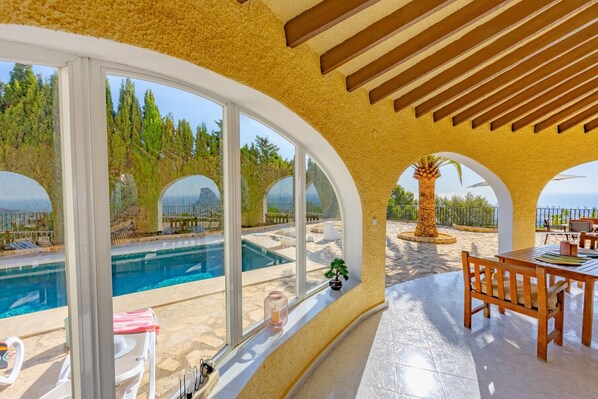 Ein Poolbereich mit Blick auf den Pool, einem Holztisch und Stühlen.