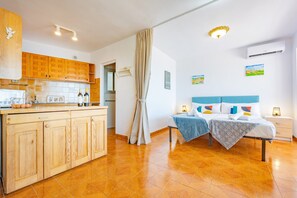 A bedroom with a bed, bedside tables, and a nightstand. There is a window with curtains. - Villa Alicia - Plus (Calpe)