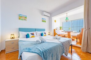 Habitació d'hotel amb llit, taules de nit, escriptori i una cadira.