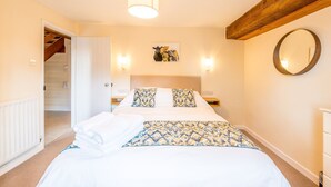 A bedroom with a bed, two bedside lamps, a wall-mounted mirror, and a ceiling light. - 4* self catering, farm stay cottage. Sleeps 4 (Boscastle)