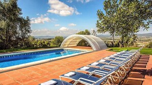 A swimming pool with lounge chairs arranged in rows, surrounded by a tiled patio and trees. - Country Chateau for 22 persons - close to Sitges! (Castellet i la Gornal)