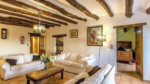 A living room with white sofas, a wooden coffee table, and exposed wooden beams on the ceiling. - Country Chateau for 22 persons - close to Sitges! (Castellet i la Gornal)