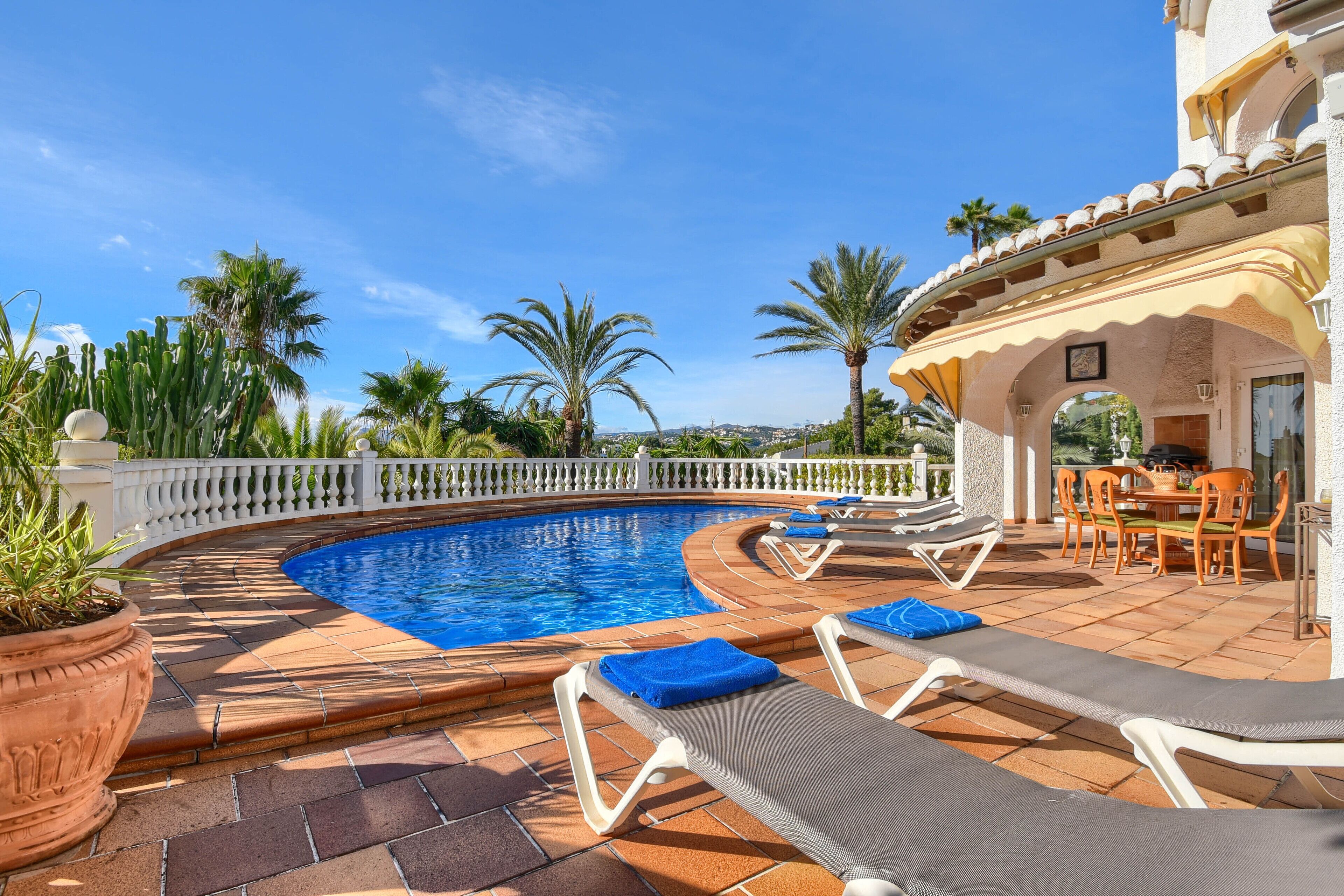 A pool area with lounge chairs and a dining set.