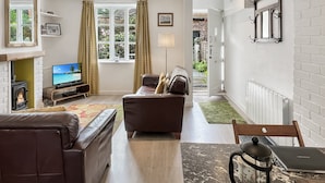 A living room with a fireplace, a television, a sofa, and a coffee table. - Grace Cottage, Porlock (Porlock)