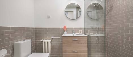 A modern bathroom with a toilet, sink, and shower area.