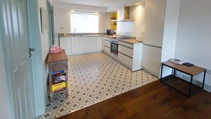 A compact kitchen with white cabinets, a built-in oven, and a small countertop. - Higher O'Connell 2 Kinsale, Co. Cork (Kinsale)