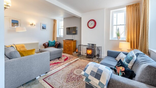 A cozy living room with a fireplace, sofas, and a television.