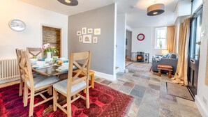 Un espace repas moderne avec un tapis à motifs rouges, des chaises en bois et une table mise pour le repas.