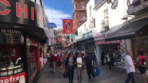 A busy street with various shops and people walking. - SANTO DOMINGO APARTMENT R030 (Benidorm)