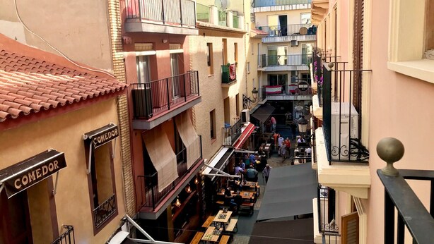 A narrow street with outdoor seating and a restaurant named "COMEDOR". - SANTO DOMINGO APARTMENT R030 (Benidorm)