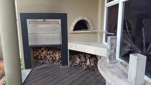An outdoor pizza oven with a stone bench and a window. - A REAL HOME AWAY FROM HOME EXPERIENCE.... (Cape Town)
