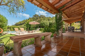 A covered patio with a pool, lounge chairs, and a stone bench. - Cozy and Comfy just 1 km to Old Town Pollensa! (Palma de Mallorca)