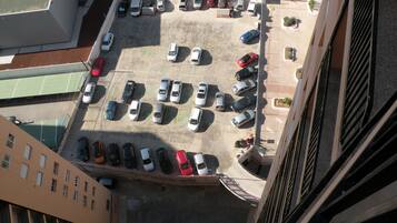 Vista aérea de un estacionamiento con varias filas de coches aparcados.