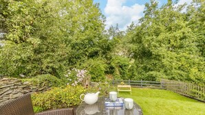 A round glass table with a teapot, two cups, and a placemat with a name and date.