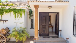 A traditional building with a tiled roof, a wooden door, and a potted plant. - Cubo's Villa Bellavista La Jona & Heated Pool / BBQ / wifi / fireplace / heated pool (Alhaurin de la Torre)