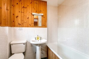 Un baño con inodoro, lavabo y bañera.