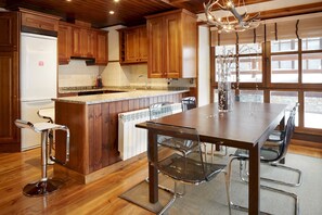 A modern kitchen with wooden cabinets, a granite countertop, and a central island with seating.