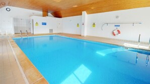 A swimming pool with tiled walls and a wooden ceiling. - 2 Bed in Clifton Court (oc-fl24) (Croyde)