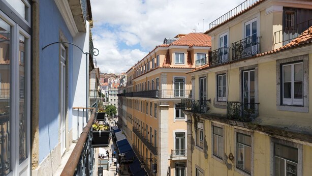 A narrow street with buildings on either side, balconies, and a pedestrian walkway. - ❤️The Traditional Arts Tribute | Sunny Balcony at Downtown! (Lisbon)