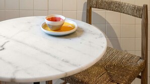 A round marble table with a bowl and saucer, a wicker chair, and a sign reading "Sunday Breakfast Club" on the wall. - ❤️The Traditional Arts Tribute | Sunny Balcony at Downtown! (Lisbon)