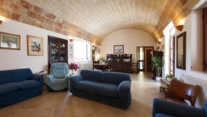 Amplia sala de estar con un techo abovedado, chimenea y comedor.